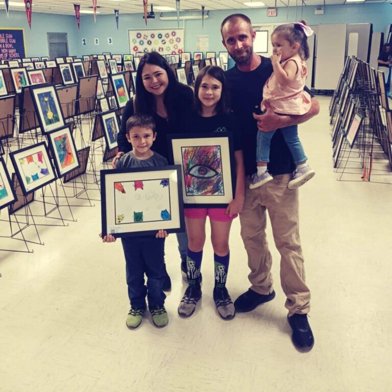 Tru Visionz owners with their family at a children’s art event, reflecting the creativity and community behind our custom signage and design business.