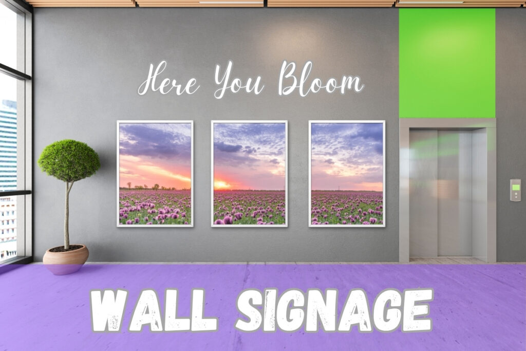 Interior wall signage with three framed floral sunset prints and vinyl text reading “Here You Bloom,” designed and installed by Tru Visionz.